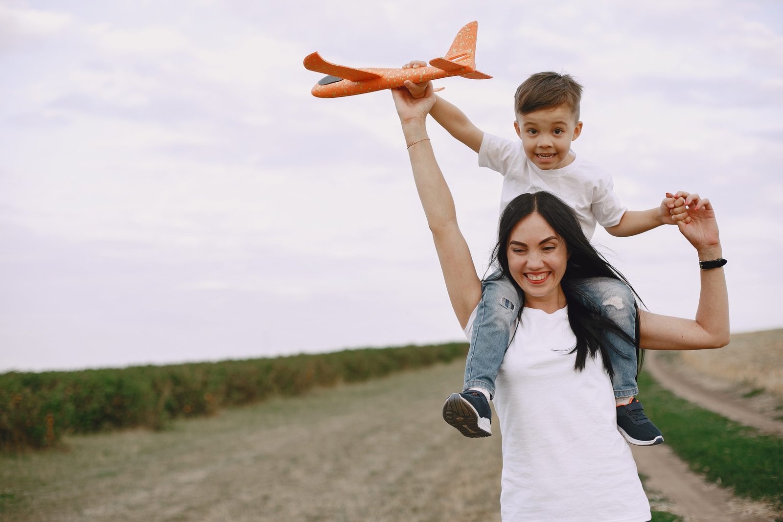 mother-with-little-son-playing-with-toy-plane-scaled